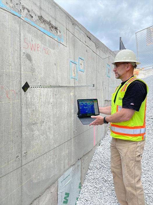 Ultrasonic imaging to detect voids inside concrete walls. The scan is taken at the location of the tape, and results are displayed on the tablet.